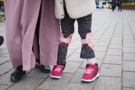 Child with leg braces enjoying a day outdoors in the cityの写真素材