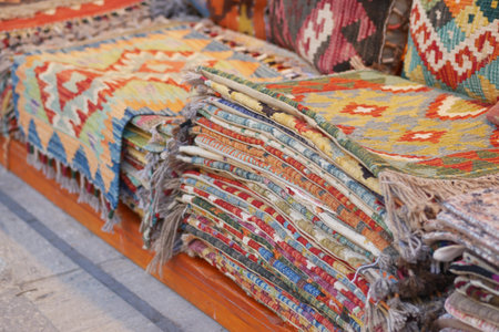 Colorful woven rugs displayed in a market for visitors