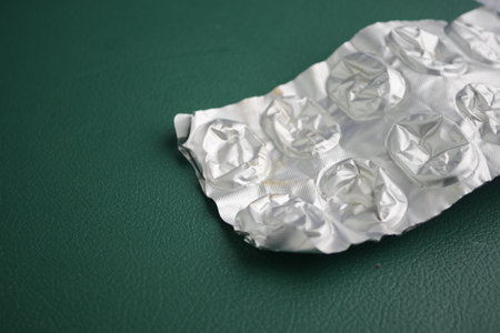 Empty blister pack on green surface after medication useの写真素材