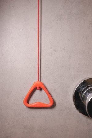 toilet alarm pull cord on a grey wall in a bathroom