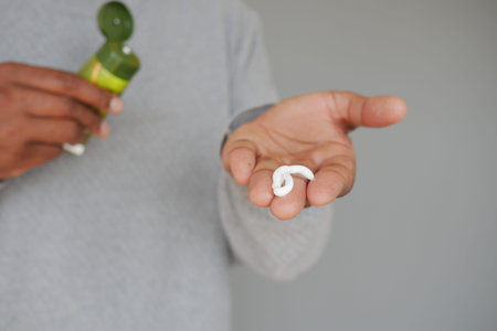 Applying skincare product in natural light indoorsの写真素材