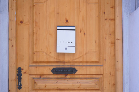 Wooden door with a sleek mail slot in a residential areaの写真素材