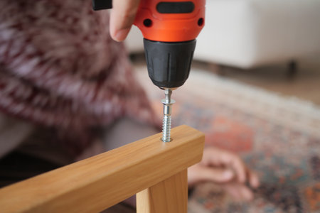 Screw drilling into wooden furniture during assemblyの写真素材