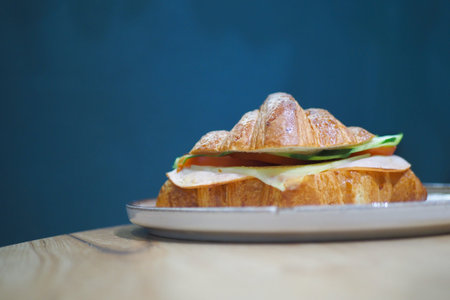 Savory croissant sandwich on a wooden table