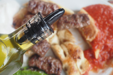 Olive oil drizzled over grilled meat and bread dishの写真素材