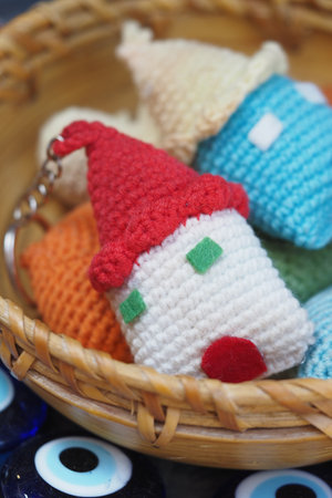 Colorful handmade keychains displayed in a woven basketの写真素材