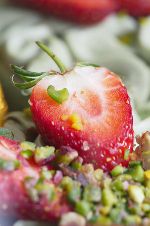 Fresh strawberry topped with pistachios on a plateの写真素材