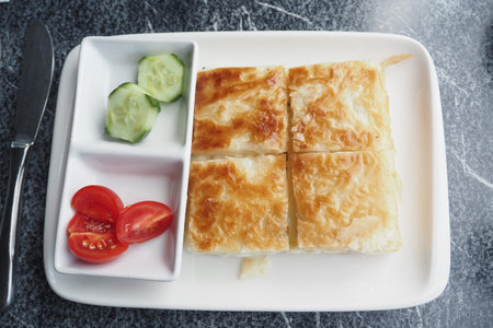Savory turkish borek served with fresh vegetables on a plate