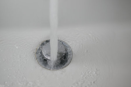 Water flowing into a drain in a white bathtubの写真素材