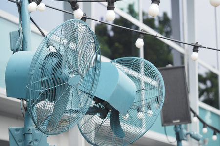 Outdoor fans providing cool breeze under string lights