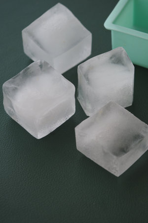 Perfectly shaped ice cubes on a green trayの写真素材