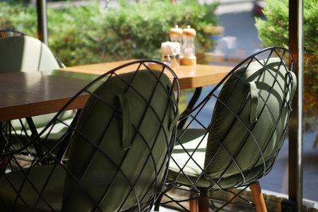 Elegant outdoor seating at cafe with greenery backdropの写真素材