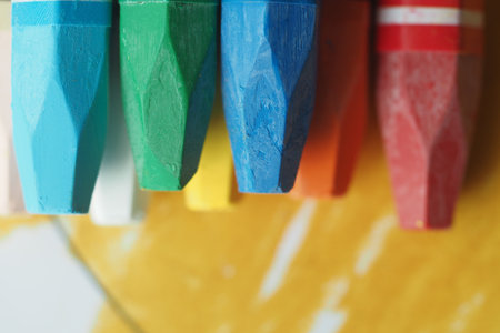 Colorful crayons lined up against a vibrant backdropの写真素材