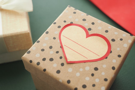Gift box with heart design on a green backgroundの写真素材