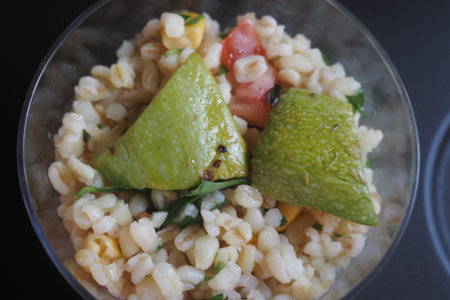 Colorful barley salad with fresh vegetables and limeの写真素材