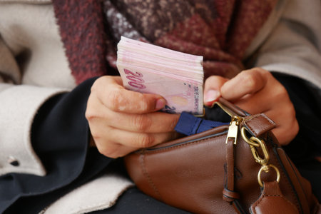 Counting cash while sitting in a cozy cafeの写真素材