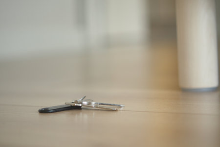 Keys resting on a wooden floor near a table leg, lost key conceptの写真素材