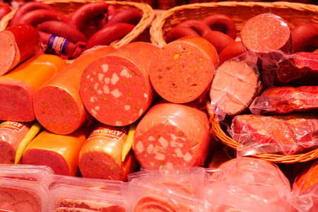 Fresh deli meats displayed at a vibrant marketの写真素材