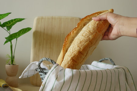 Freshly baked bread being picked from a basket