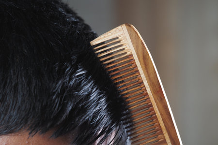 Combing hair with a wooden comb in a simple setting