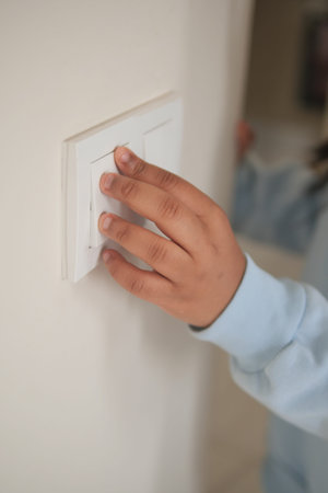 Child turning off light switch in a cozy room