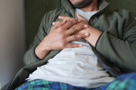 Man suffering chest pain laying on bedの写真素材