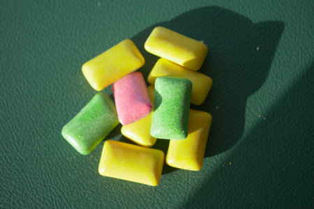 Colorful chewing gum arranged on a green surfaceの写真素材