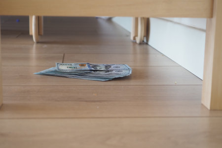 Money placed under furniture in a casual home setting, lost cash conceptの写真素材
