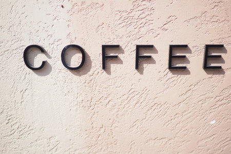 Coffee shop sign on a textured wall in daylightの写真素材