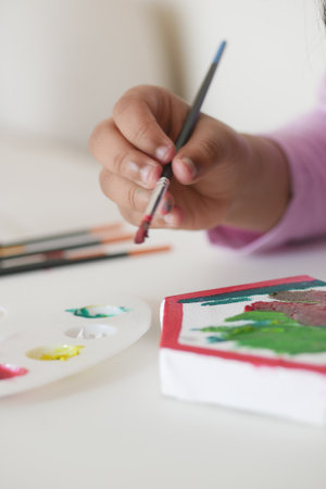 Young artist paints on canvas with vibrant colorsの写真素材