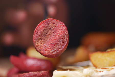 Delicious sausage slice showcased on a wooden tableの写真素材