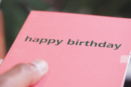 Person holding a birthday card in celebration outdoorsの写真素材