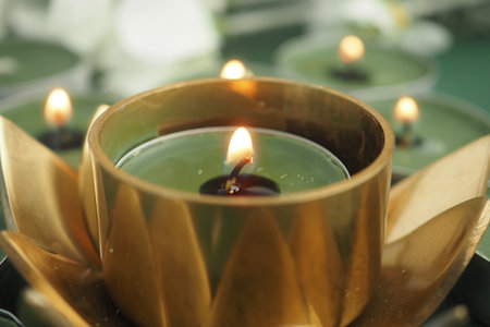 Elegant green candle in a decorative holder glowing softlyの写真素材