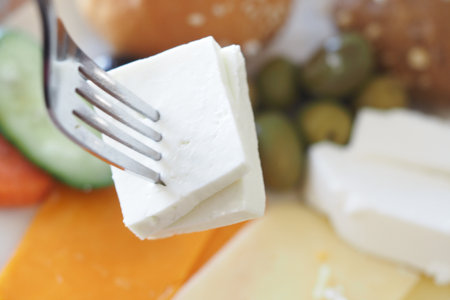 Delicious selection of cheeses and vegetables on a forkの写真素材