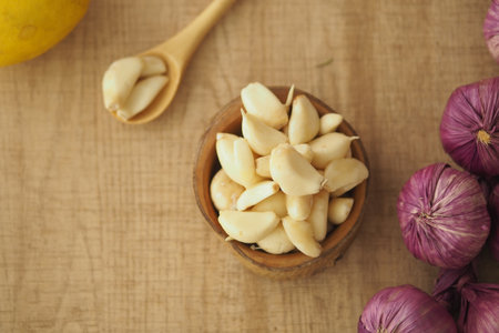 Fresh garlic cloves and red onions on wooden surfaceの写真素材