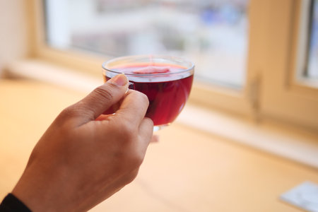 Enjoying a cup of herbal tea near the windowの写真素材