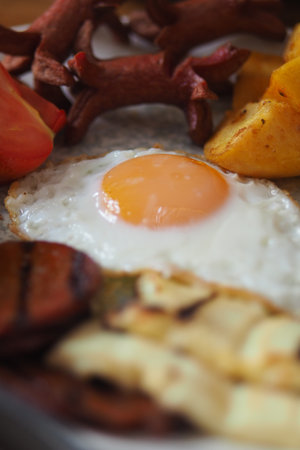 Delicious breakfast with eggs, sausage, and vegetablesの写真素材