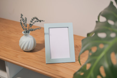 Display of a light blue picture frame with a vaseの写真素材