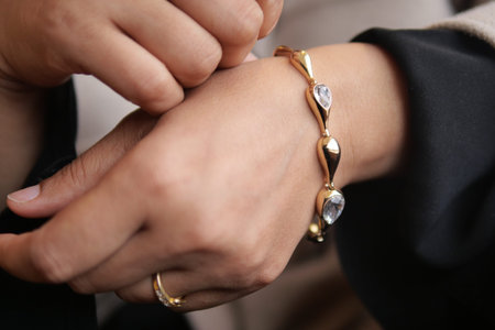 Elegant gold bracelet being worn on a stylish hand