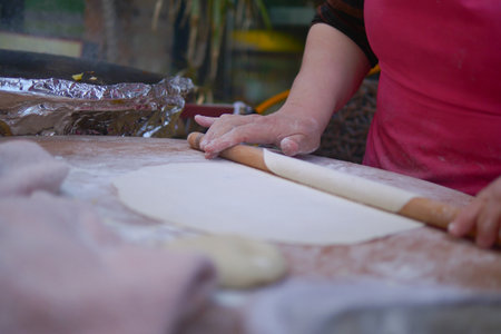 Rolling dough in a kitchen during the dayの写真素材