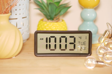 Digital clock displaying time and date on a wooden table