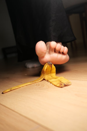 Slipping on a banana peel in a cozy indoor settingの写真素材