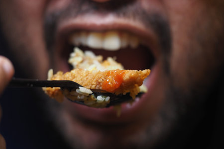 Enjoying a flavorful bite of chicken and rice at dinnerの写真素材