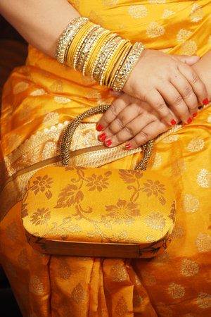 Elegant woman in yellow attire holding stylish handbagの写真素材