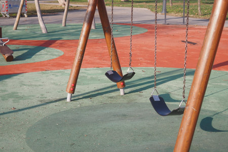 Empty swings at a colorful playground in sunny afternoonの写真素材