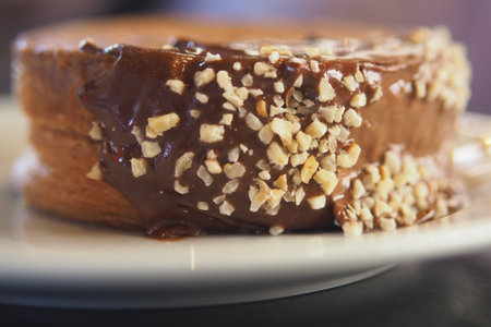Delicious pastry topped with chocolate and nuts on a plateの写真素材