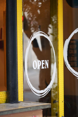 Shop welcomes customers with an open sign on the doorの写真素材