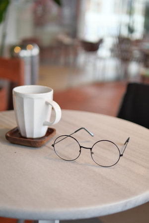 Coffee and glasses on a table in a modern cafeの写真素材