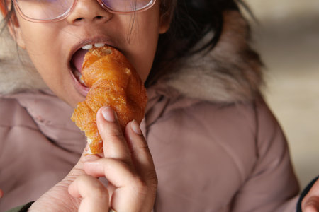 Child enjoys a pastry in a cozy settingの写真素材