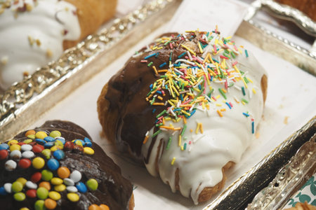 Colorful desserts displayed at a bakery on a bright day